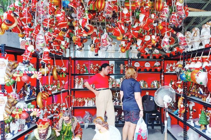 toys_copy_resized A customer checks out the various hanging Christmas toys and decors such as Santa Clausses, angels, candy canes, and other holiday season ornaments on sale in this shop along JP Laurel Avenue in Davao City. PNA