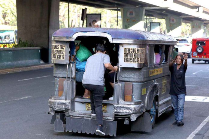 A commuter boards a public utility jeepney plying Taft Avenue in Manila. The Public Utility Vehicle modernization program of the government may cause jeepney drivers and operators to lose their livelihood. PNA