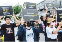 Thai Amnesty International activists hold placards during a demonstration in Bangkok calling for the release of political prisoners convicted under the lese majeste law. GETTY IMAGES