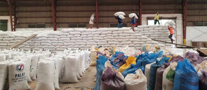 Personnel of the National Food Authority pile up the rice stock at a warehouse in Capiz province. NFA CAPIZ VIA PIA