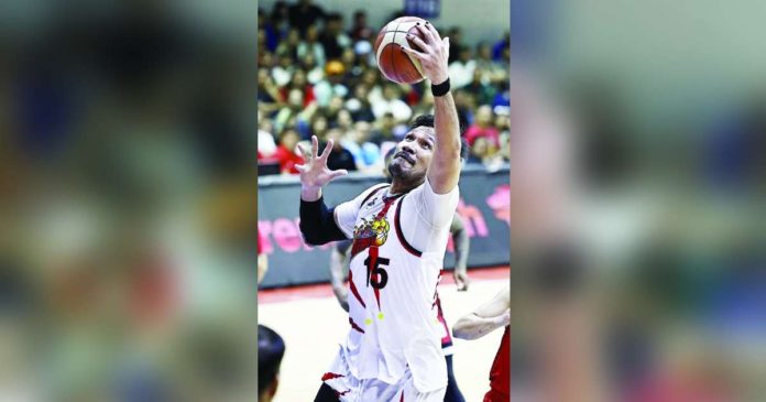 San Miguel Beermen’s June Mar Fajardo towers over his Barangay Ginebra San Miguel Kings’ defenders for a rebound. PBA PHOTO