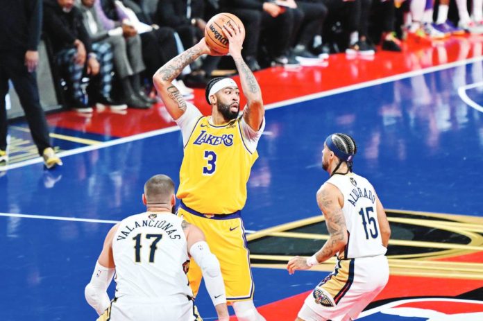 sports_no_pelicans_resized Los Angeles Lakers’ Anthony Davis looks to pass the ball while being defended by New Orleans Pelicans’ Jonas Valanciunas and Jose Alvarado. NBA PHOTO