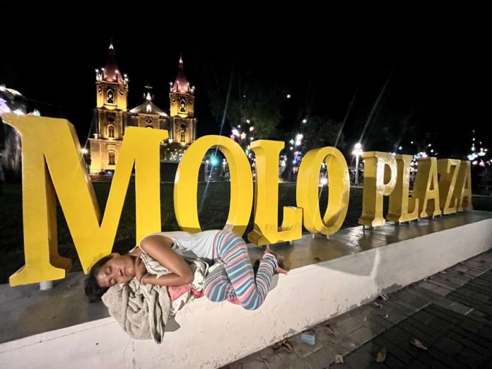 vagrant_pic.JPG_resized While others are already sleeping in comfortable beds or enjoying good food and drinks with their loved ones, a vagrant sleeps at the signage of Molo Plaza in Molo, Iloilo City in the evening of Jan. 1, 2024. PHOTO BY HAZEL P. VILLA, CONTRIBUTOR