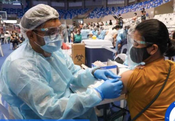 CHR A woman gets vaccinated during a mass COVID-19 vaccination at the Makati Coliseum. IMAGE FROM FACEBOOK / MYMAKATI