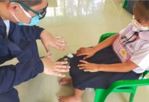 A health worker examines the hand of a girl in Batangas to check on possible signs of hand-foot-and-mouth disease (HFMD), a mild, contagious viral infection common in young children. PHOTO COURTESY OF RAPPLER