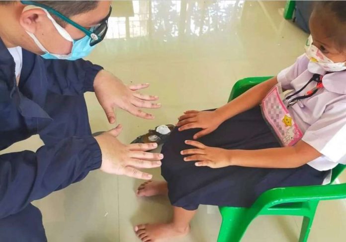HFMD_pic.JPG_resized A health worker examines the hand of a girl in Batangas to check on possible signs of hand-foot-and-mouth disease (HFMD), a mild, contagious viral infection common in young children. PHOTO COURTESY OF RAPPLER