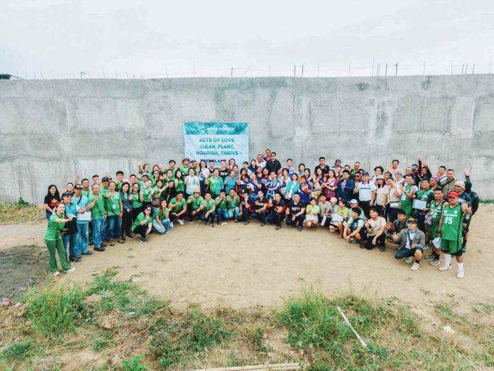 banner_pic_resized MORE Electric and Power Corporation employees proudly do the four-finger sign, symbolizing their four years of operation in Iloilo City since 2020, following a tree planting activity.