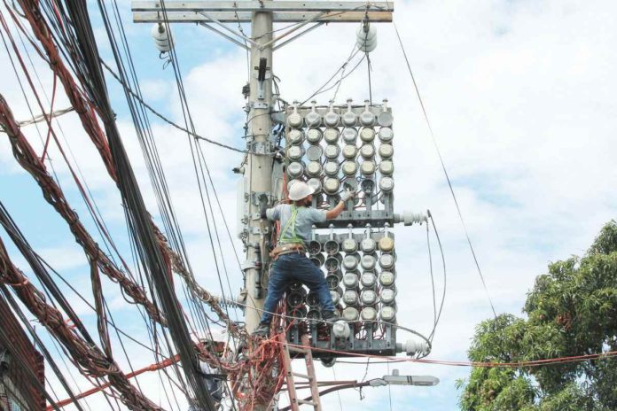 power_rates_resized One of the Manila Electric Co. linemen inspects the power meters on a concrete post along Kaliraya Street in Quezon City. PNA PHOTO BY JESS M. ESCAROS JR.