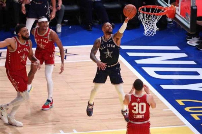 sports dame Damian Lillard of East All-Star stretches for a layup as West All-Star's Stephen Curry looks on. PHOTO COURTESY OF REUTERS