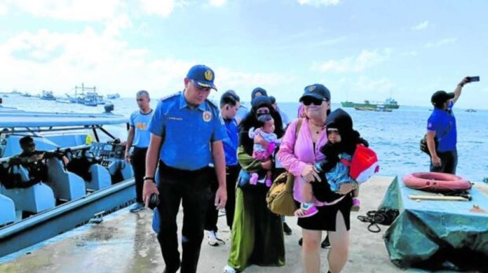 Photo provided by the Presidential Anti-Organized Crime Commission shows police on Thursday accompanying two women, one of them terror suspect Myrna Mabanza, in Pasil village, Indanan, Sulu. INQUIRER FILE PHOTO / GRIG C. MONTEGRANDE