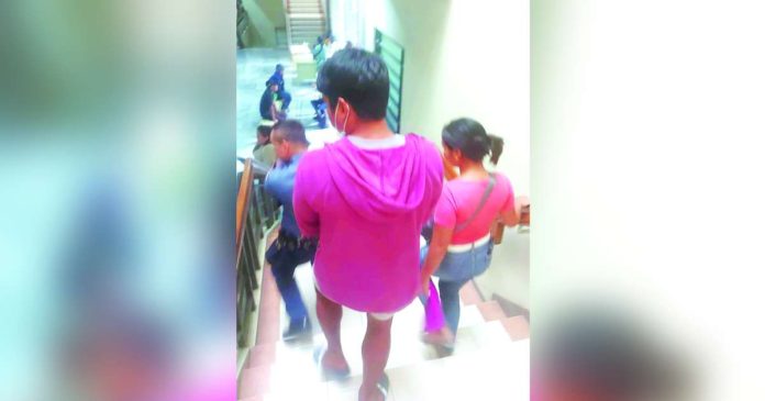CHARGED. A policeman escorts this man in red hoodie after getting legal advice from the Public Attorney’s Office at the Iloilo Hall of Justice. The suspect faces a complaint for alleged acts of lasciviousness filed by 21 high school students. He was brought to the Iloilo Provincial Prosecutor’s Office for inquest proceedings on Feb. 19. BY GEROME DALIPE IV/PN