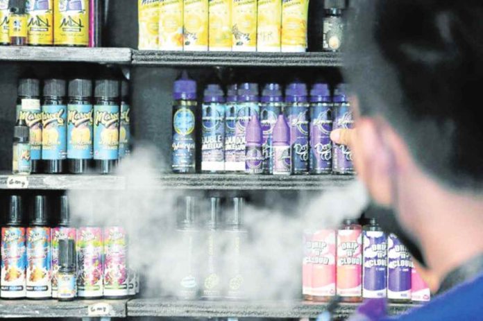 A store helper arranges products at a vape shop in Quezon City in this 2022 photo. As of January, the Department of Trade and Industry has intensified its efforts against illegal vape sellers, issuing notices of violations and show cause orders to 269 stores. GRIG C. MONTEGRANDE, PHILIPPINE DAILY INQUIRER