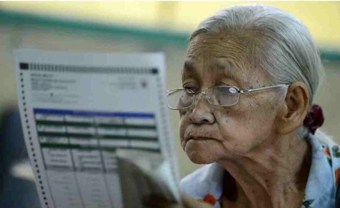 An elderly woman checks her ballot paper in this undated election photo. Last year, the Commission on Elections had a test run of earlier voting for senior citizens, persons with disabilities, and pregnant women in some areas. AFP/GETTY IMAGES