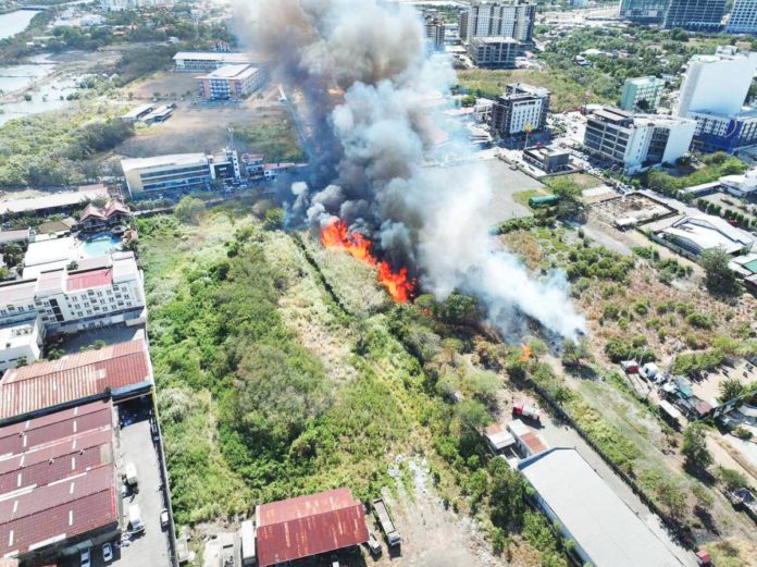 A GRASS FIRE broke out on a vacant lot in Barangay San Rafael, Mandurriao, Iloilo City on Wednesday afternoon, March 27, as seen in this drone shot. The Bureau of Fire Protection Region 6 stressed the importance of public cooperation in maintaining clean surroundings to prevent grass and garbage fires especially with the ongoing El Niño phenomenon. ILOILO CITY OPCEN PHOTO