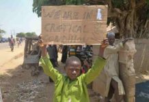 A boy holds a sign to protest against the kidnapping of nearly 300 schoolchildren this week. REUTERS