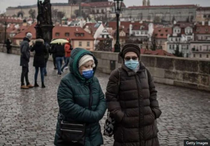 world_czech_resized Two women walk side by side in Prague wearing face masks. GETTY IMAGES