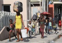 Over 50K flee violence-hit Haiti capital People walk towards a shelter with their belongings fleeing from violence around their homes, in Port-au-Prince, Haiti. REUTERS