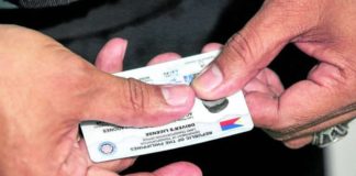 A Land Transportation Office (LTO) staff member shows a brand new student driver’s license at the LTO Quezon City District Office in Centris Station. The LTO had been facing a supply shortage of plastic cards for driver’s licenses. INQUIRER PHOTO/LYN RILLON