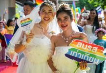 A same-sex couple participates in a pride march through central Bangkok. SHUTTERSTOCK