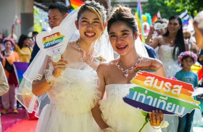A same-sex couple participates in a pride march through central Bangkok. SHUTTERSTOCK