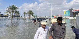 People walk through floodwater caused by heavy rains in Dubai, United Arab Emirates. Dubai has been hit by record floods. GETTY IMAGES