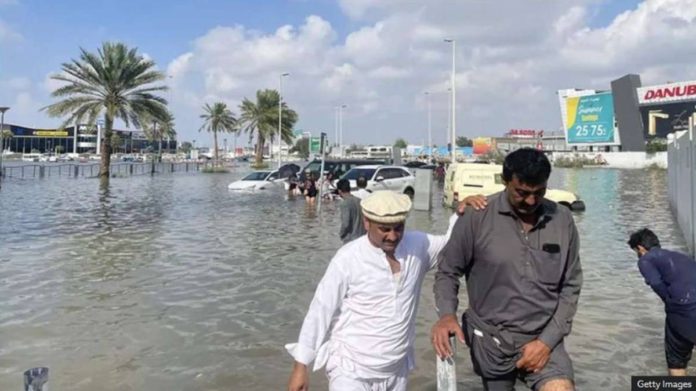 People walk through floodwater caused by heavy rains in Dubai, United Arab Emirates. Dubai has been hit by record floods. GETTY IMAGES