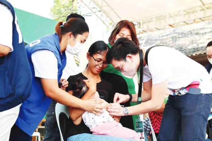 Dr. Jose Martin Atienza, regional coordinator for the National Immunization Program at the Department of Health – Region 6 administers a measles-rubella vaccine on a child as part of the 1st Regional World Immunization Week Celebration and MR-bOPV Supplemental Immunization Activity Kick-Off held in Kabankalan City, Negros Occidental last year. DOH WV CHD via Philippine Information Agency – Western Visayas