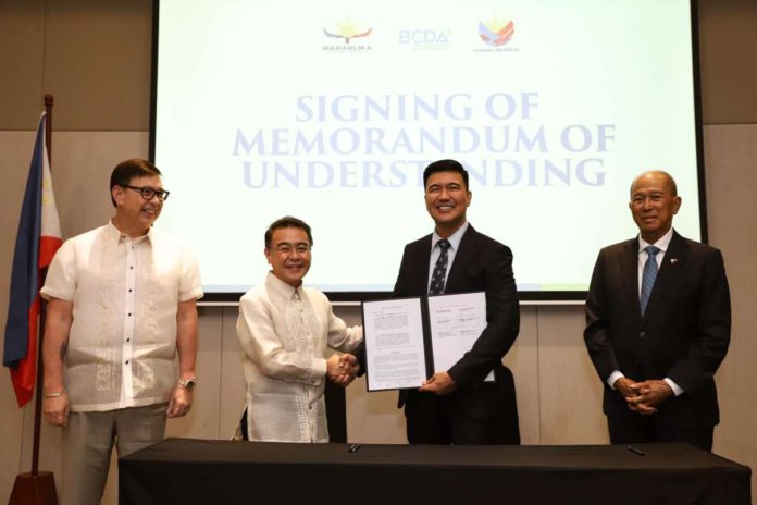 maharlika_resized Maharlika Investment Corp. (MIC) president/CEO Rafael Consing Jr. and Bases Conversion and Development Authority (BCDA) counterpart Joshua Bingcang (2nd and 3rd from left) sign agreements in Taguig City on Monday, April 29, to explore investments within BCDA properties. Witnessing the signing are Finance Secretary and MIC chair Ralph Recto (left) and BCDA chair Delfin Lorenzana. BCDA PHOTO