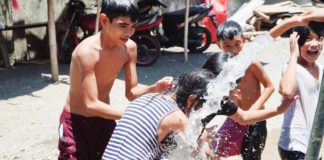 MORE Electric and Power Corporation provides free cold water for washing and bathing to 12 Iloilo City barangays affected by power interruptions on Sunday, April 21. Photo shows children in Barangay Cubay, Jaro district enjoying taking a bath from the hose of a fire truck. PHOTO BY MORE POWER