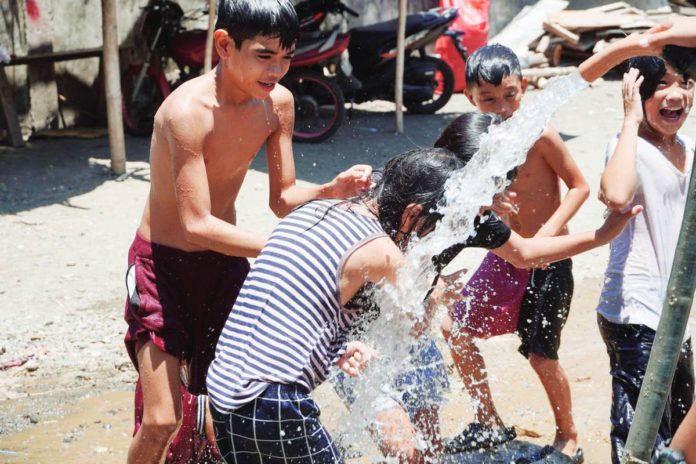more_power_pic_resized MORE Electric and Power Corporation provides free cold water for washing and bathing to 12 Iloilo City barangays affected by power interruptions on Sunday, April 21. Photo shows children in Barangay Cubay, Jaro district enjoying taking a bath from the hose of a fire truck. PHOTO BY MORE POWER