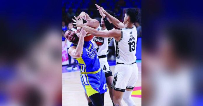Magnolia Chicken Timplados Hotshots’ James Laput gets clobbered by the defense of Blackwater Bossing’s Clifford Jopia. PBA PHOTO