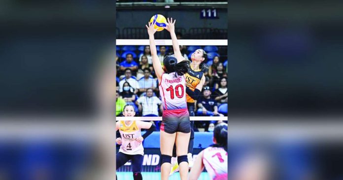 sports poyos.JPG_superimposed University of Santo Tomas Golden Tigresses’ Angeline Poyos smashes the ball towards the University of the East Lady Warriors defense. UAAP PHOTO