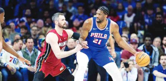 Philadelphia 76ers’ Joel Embiid (21) controls the ball against Miami Heat’s Kevin Love (42). Photo courtesy of Bill Streicher/USA TODAY Sports