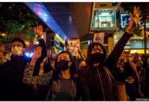 People chant slogans near a Hong Kong police-cordoned-area to show support for a small group of protesters. GETTY IMAGES