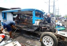 Junk shop workers dismantle a public utility jeepney in Tondo, Manila. Operators and drivers who did not consolidate their units with cooperatives under the modernization program will be disenfranchised. PNA
