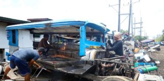 Junk shop workers dismantle a public utility jeepney in Tondo, Manila. Operators and drivers who did not consolidate their units with cooperatives under the modernization program will be disenfranchised. PNA