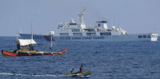 A China Coast Guard ship monitors Philippine fishermen aboard their wooden boats during the distribution of fuel and food to fishers by the civilian-led mission Atin Ito (This Is Ours) Coalition, in the disputed South China Sea on May 16, 2024. A Philippine boat convoy bearing supplies for Filipino fishers said they were headed back to port May 16, ditching plans to sail to a Beijing-held reef off the Southeast Asian country after one of their boats was “constantly shadowed” by a Chinese vessel. Ted Aljibel/Agence France-Presse