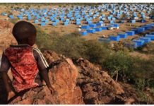 A boy sits atop a hill overlooking a refugee camp near the Chad-Sudan border. Paramilitary forces in Sudan are being accused of an ethnic cleansing amid a civil war. REUTERS