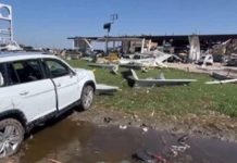 A car sits in a pile of debris after major storms through Texas. BBC