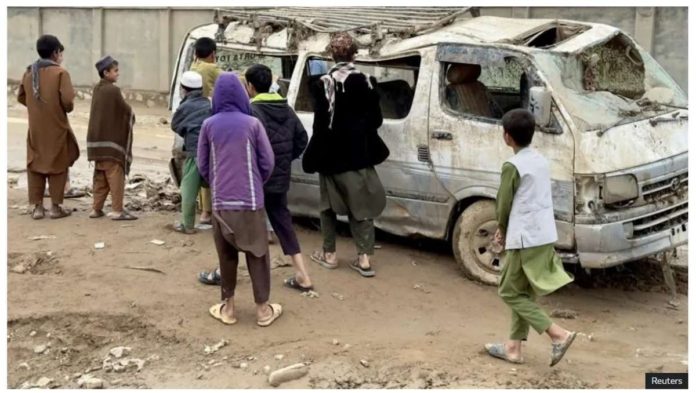 afghanistan_resized People look at a flood-wrecked vehicle in Baghlan province, Afghanistan. REUTERS