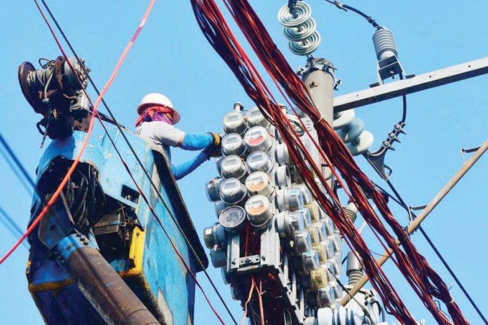 anti-bill_shock A worker inspects an electric meter installed above ground in Manila. MARK DEMAYO/ABS-CBN NEWS PHOTO