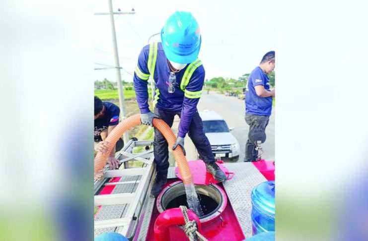 Metro Pacific Iloilo Water personnel load water atop a fire truck for distribution to drought-hit villages in Iloilo City. The major water distributor in the city ensures the water is safety by subjecting it to bacteriological tests. METRO PACIFIC ILOILO WATER PHOTO
