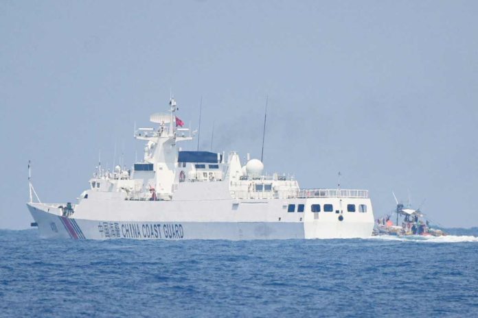 DFA_resized A China Coast Guard ship maneuvers past a Philippine fishing boat during the distribution of fuel and food to fishers by the civilian-led mission Atin Ito (This Is Ours) Coalition, in the disputed South China Sea on May 16, 2024. AFP