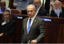 Israeli Prime Minister Benjamin Netanyahu stands in the Knesset in Jerusalem during a vote on June 19, 2024. EPA