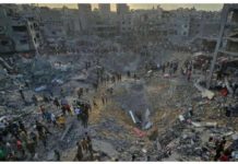 Palestinians walk past large craters and the rubble of destroyed buildings in Jabalia refugee camp, in the northern Gaza Strip. REUTERS