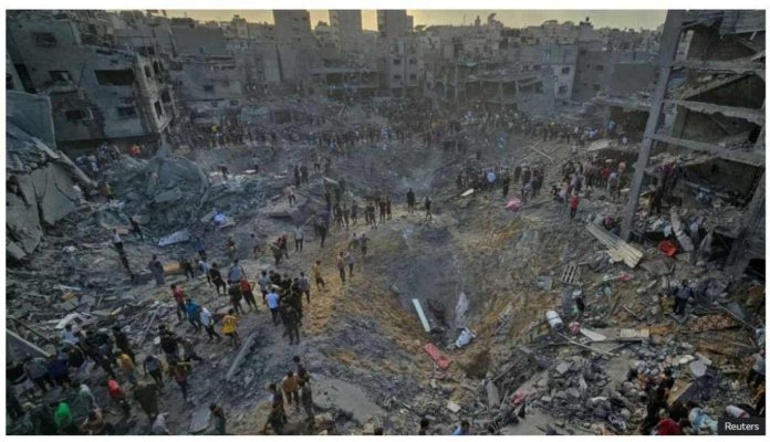 Israel_resized Palestinians walk past large craters and the rubble of destroyed buildings in Jabalia refugee camp, in the northern Gaza Strip. REUTERS