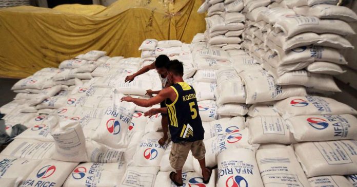Workers stack rice at a warehouse of National Food Authority. INQUIRER FILE PHOTO