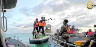 The Armed Forces of the Philippines, which released this photo, said one of the China Coast Guard members shown here (center) wielded a pickaxe and made threatening gestures in their encounter with Filipino troops on a resupply mission to Ayungin (Second Thomas) Shoal on June 17.