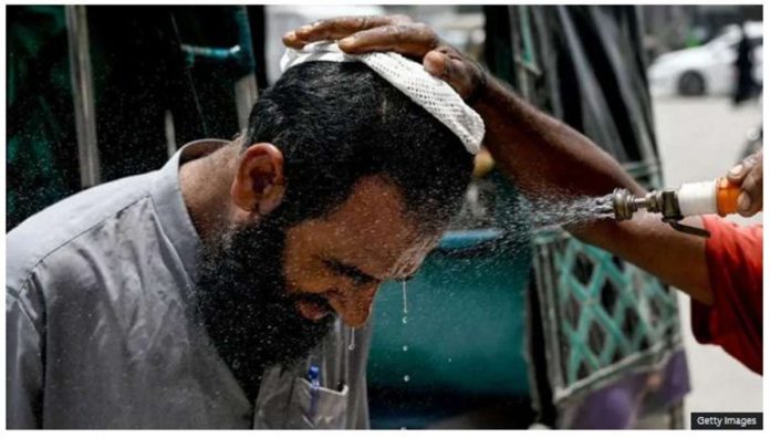 Pakistan.JPG_resized In Karachi, a volunteer sprays water on a bypasser’s face to cool off during a heat wave. GETTY IMAGES