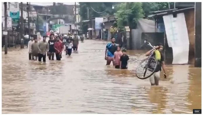 Sri_Lanka_resized People wade through knee-high floodwaters caused by heavy monsoon rains in Sri Lanka. BBC